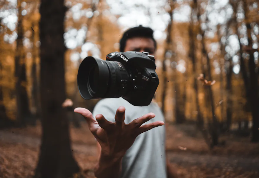 Fotógrafo con su cámara en un bosque en otoño